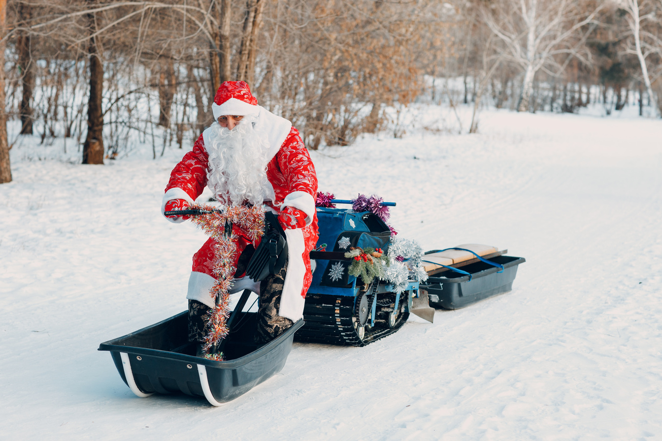 Santa Claus Riding Snowmobile in the Winter Forest